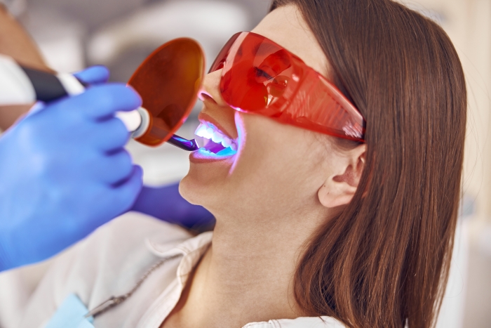 dentist using ultraviolet light on patient